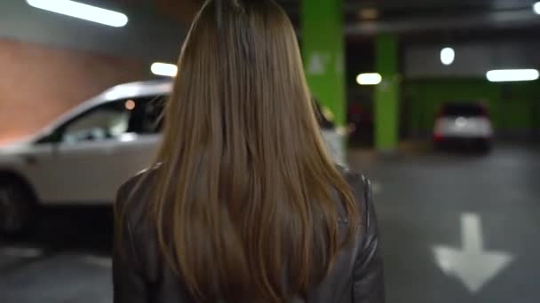 Nő megy a kocsiját, kinyitja az ajtót, és leül - Felvétel, videó