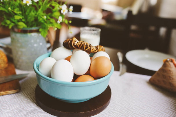 country breakfast on rustic home kitchen with farm eggs, butter, wholegrain bread and milk. Organic homemade food, easter concept.   - Foto, afbeelding