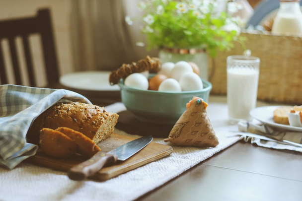 country breakfast on rustic home kitchen with farm eggs, butter, wholegrain bread and milk. Organic homemade food, easter concept.   - Fotoğraf, Görsel