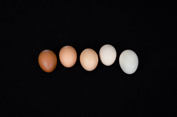 Cinco ovos de galinha orgânica fresca em fundo de feltro preto
. - Foto, Imagem
