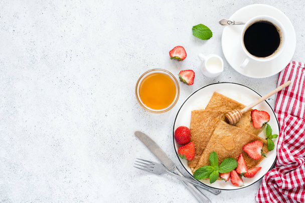Crepes, thin pancakes or blini with strawberries, honey, coffee - Foto, Imagen