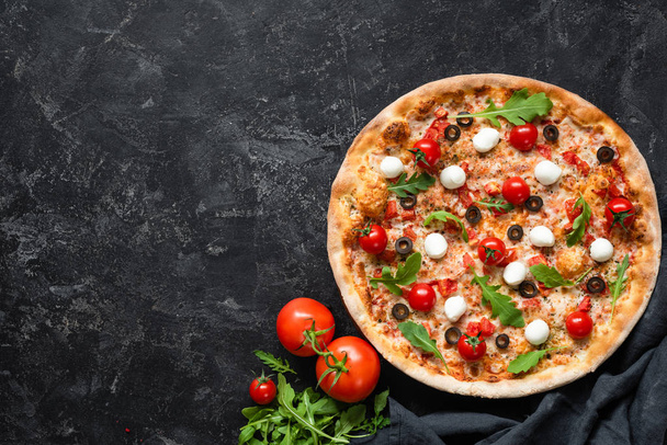 Tasty pizza with tomatoes and mozzarella on black background - Фото, зображення