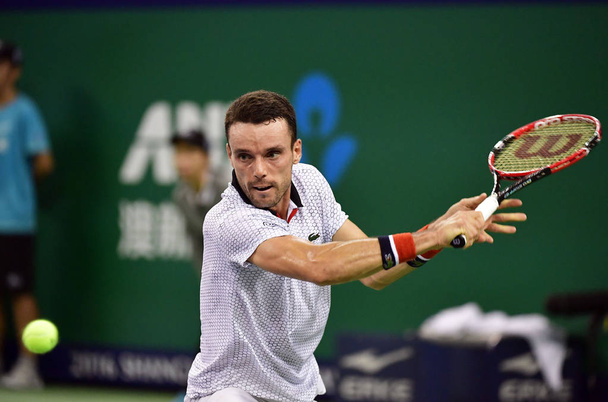 Roberto Bautista Agut of Spain hits a return shot against Novak Djokovic of Serbia in their men's singles semifinal match during the 2016 Shanghai Rolex Masters tennis tournament in Shanghai, China, 15 October 2016 - Photo, Image