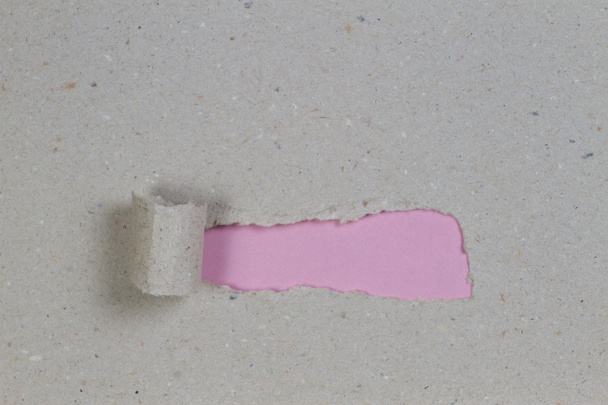 コピー スペースとピンクの背景を明らかにするために引き裂かれた茶色のパッケージ紙 - 写真・画像