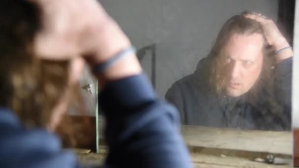 Depressiver und wütender Mann sitzt vor seinem Spiegelbild in einem alten, verlassenen Haus - Filmmaterial, Video