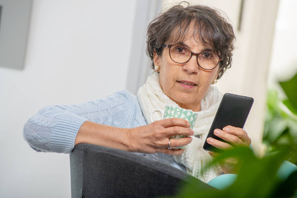 une femme d'âge moyen heureuse avec des lunettes utilisant et parlant téléphone
  - Photo, image