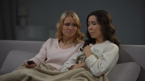Emotional women watching soap opera, sympathizing main heroes, relaxing at home - Felvétel, videó