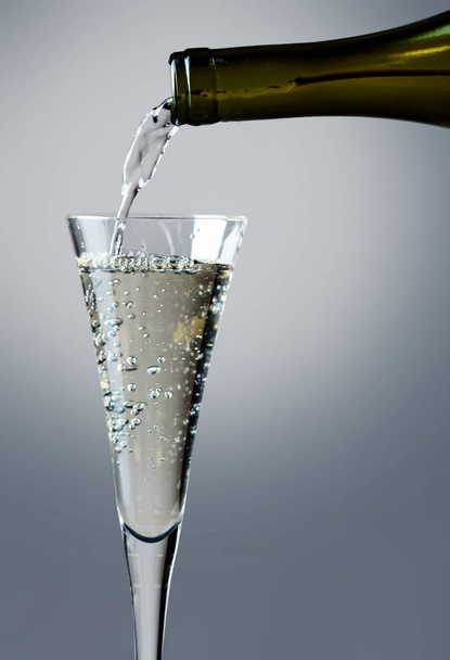 Champagne versato nel bicchiere. Flusso di vino che viene versato in un primo piano di vetro
. - Foto, immagini