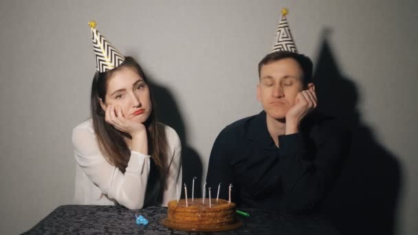 Droevige, eenzame vrouw en man in feest hoed viert verjaardag alleen. - Video