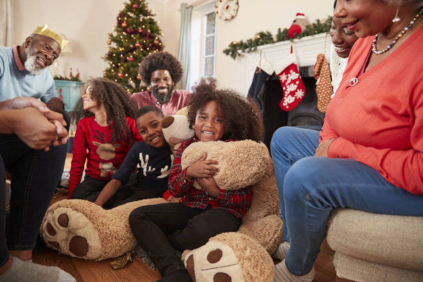 Children Playing With Giant Teddy Bear As Multi-Generation Family Opening Gifts On Christmas Day - Fotó, kép