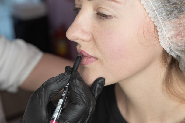 Maquiagem permanente para sobrancelhas. Testa de Microblading. Esteticista fazendo tatuagem de sobrancelha para rosto feminino. Menina bonita em uma beleza
 - Foto, Imagem