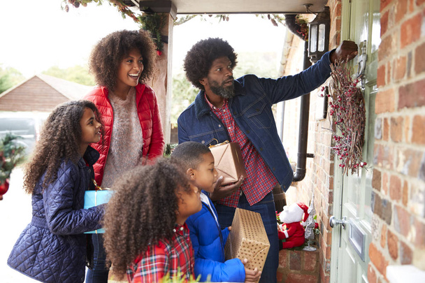 Family Knocking On Front Door As They Arriving For Visit On Christmas Day With Gifts - Photo, Image