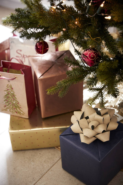 Gifts arranged under a decorated Christmas tree, close up - Foto, imagen