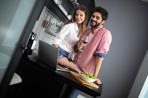Image of happy couple with glasses of red wine eating salad - Photo, image