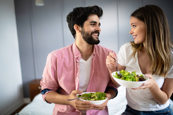 Image of happy couple eating salad at home - Foto, Imagem