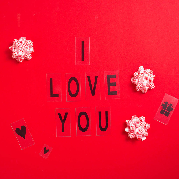 Kocham Cię napisane w czarne litery na jasnym tle czerwony. Koncepcja Walentynki - Zdjęcie, obraz