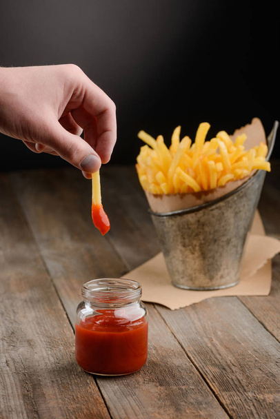 Hand dips French fry - Фото, изображение