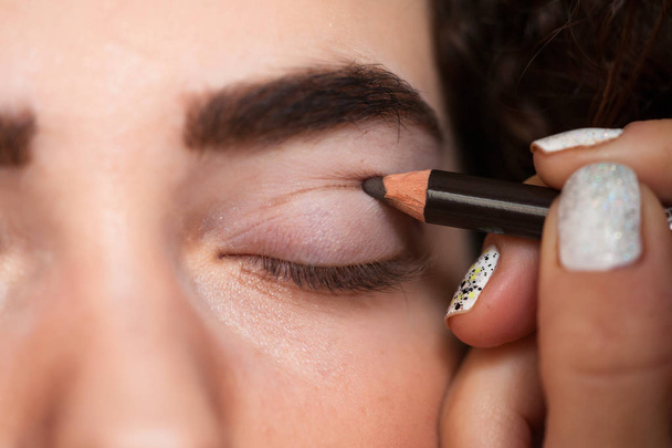 With the help of a Cosmetic pencil, paint a thick line on your cut crease. Beauty and makeup concept - 写真・画像