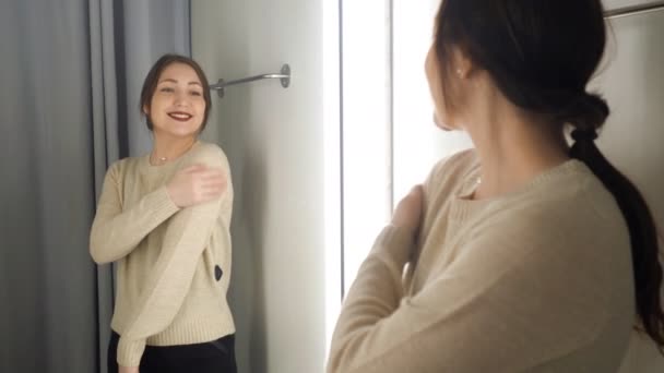 brunette fille mesure les vêtements dans une salle d'essayage
 - Séquence, vidéo