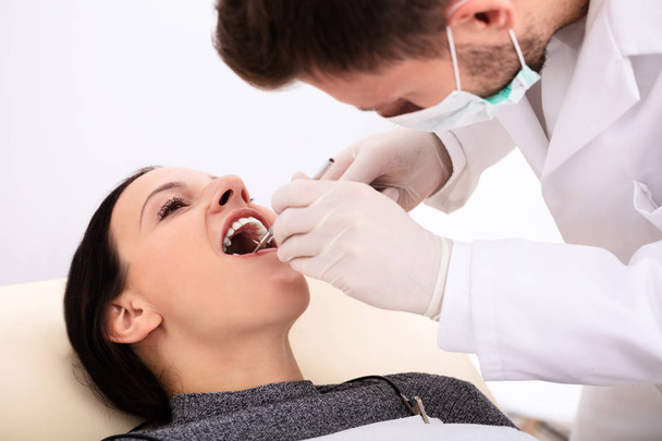 Close-up Of Dentist Examining Young Woman's Teeth In Clinic - Valokuva, kuva