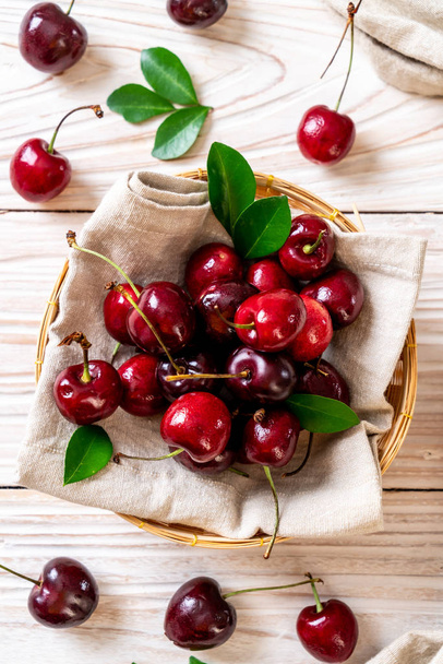 Fresh cherries in bowl  on wood background - Fotó, kép