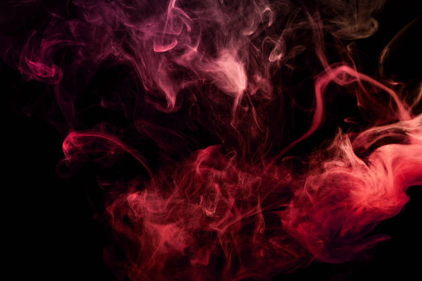 Thick yellow and red smoke on a black isolated background. Background from the smoke of vap - Foto, afbeelding