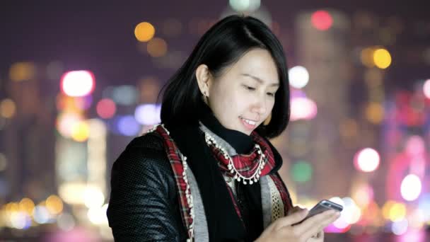 Γυναίκα χρήση του έξυπνου τηλεφώνου το βράδυ στο Χονγκ Κονγκ - Πλάνα, βίντεο