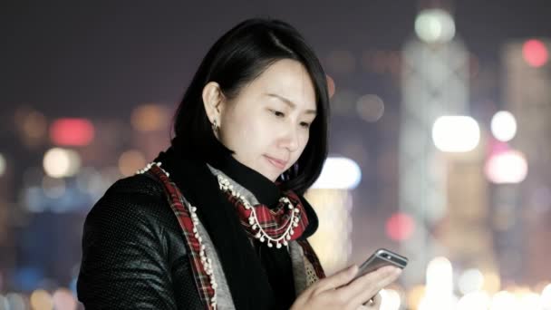 Žena použití chytrých telefonů v noci v Hong Kongu - Záběry, video