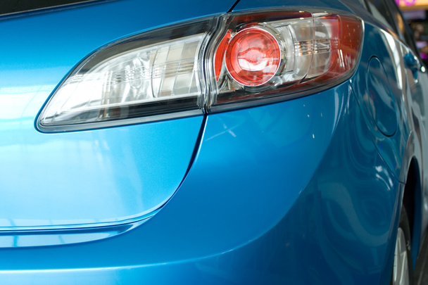 σύγχρονο κόκκινο φως πίσω από ένα μπλε αυτοκίνητο - Φωτογραφία, εικόνα