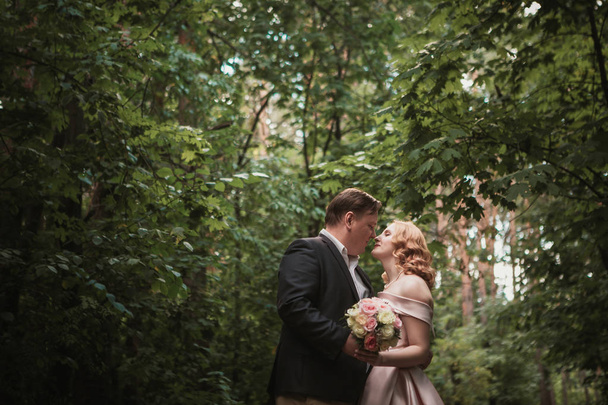 bride and groom dancing in the forest background and sunlight. - Photo, Image
