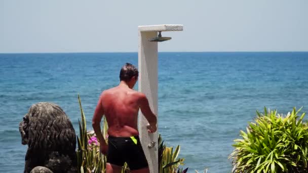 man en douche op het strand - Video
