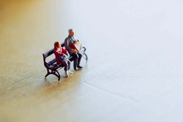 Miniature couple sitting together in warm light . Valentine day consept. - Photo, Image