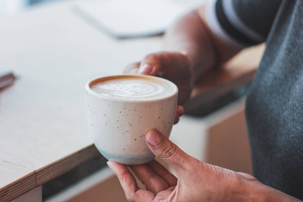 La femme adulte d'âge moyen tient dans la main cappuccino café
 - Photo, image