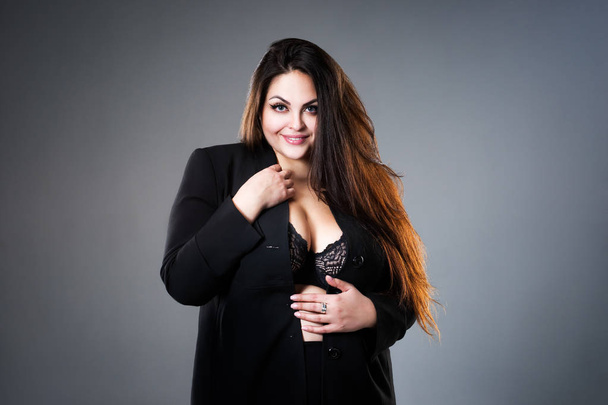 Plus size fashion model in sexy clothes, fat woman on gray studio background, overweight female body - 写真・画像