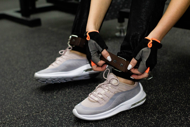  Close up front view of woman's hands tying shoelaces on sneakers in the gym. girl tying shoelaces on sneakers. - Fotografie, Obrázek