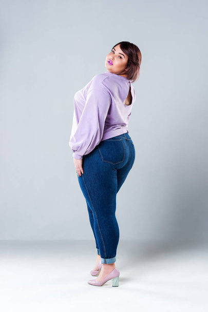 Plus size fashion model in casual clothes, fat woman on gray studio background, overweight female body - Fotó, kép