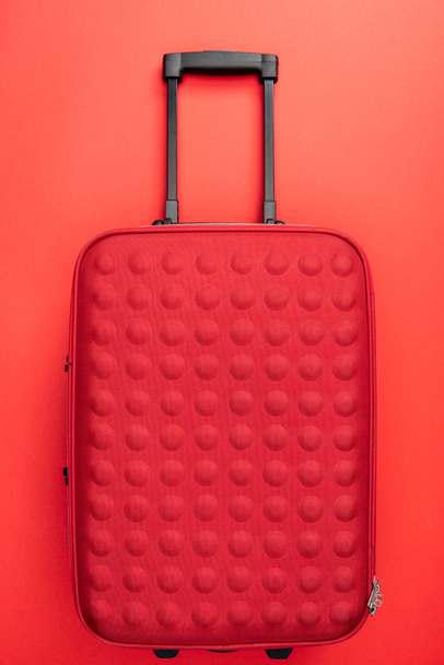 pohled shora na cestovní tašku na červeném pozadí  - Fotografie, Obrázek