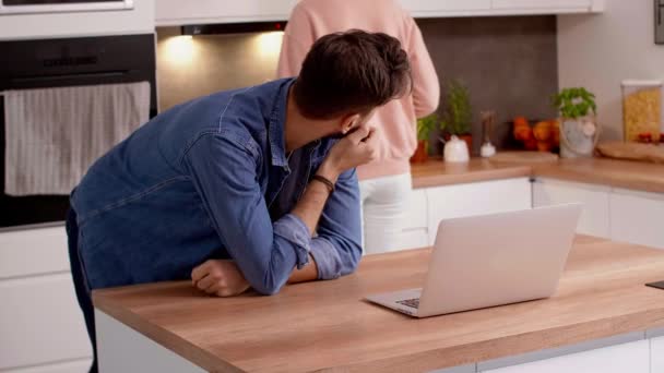 Couple using laptop in the kitchen - Materiał filmowy, wideo
