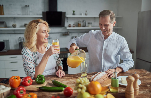 Senior couple is cooking on kitchen. Beautiful woman and handsome man are spending time together at home. Healty lifestyle concept. - Foto, afbeelding