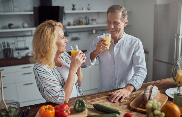 Senior couple is cooking on kitchen. Beautiful woman and handsome man are spending time together at home. Healty lifestyle concept. - Foto, Bild
