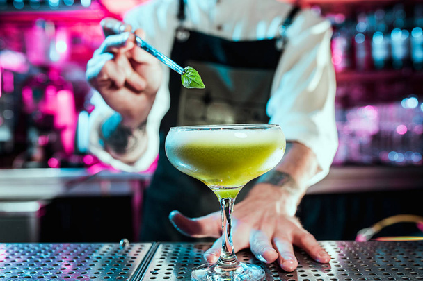 Expert barman is making cocktail at night club. - Zdjęcie, obraz