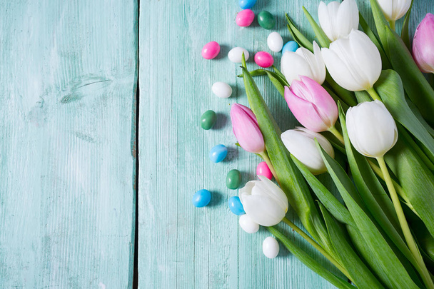 tulips and easter candies on wooden surface - 写真・画像