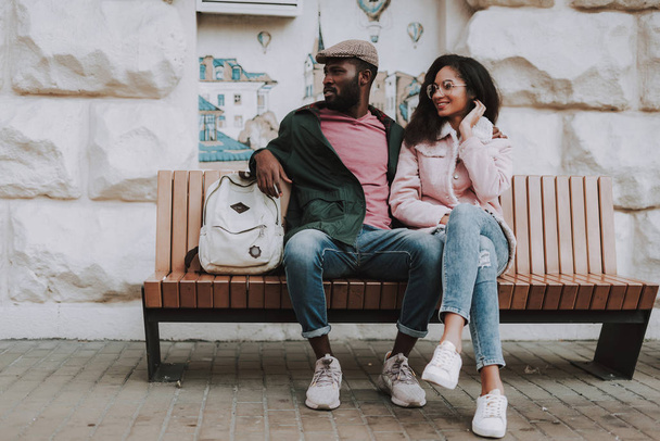 Cheerful beloved couple sit on street bench - Photo, image