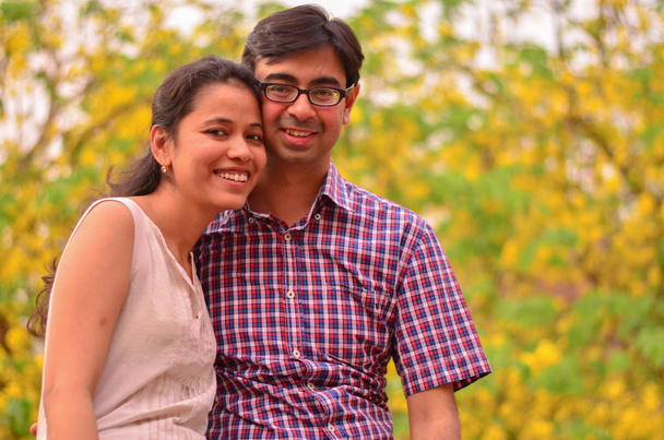 黄色に敵対を笑顔若いインド カップル葉秋の天気でデリー、インド - 写真・画像