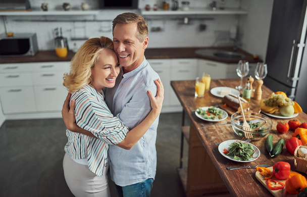 Senior couple is cooking on kitchen. Beautiful woman and handsome man are spending time together at home. Healty lifestyle concept. - Фото, зображення