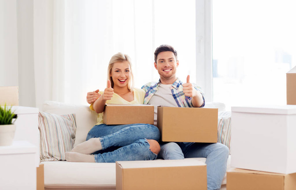 happy couple with boxes moving to new home - Photo, image
