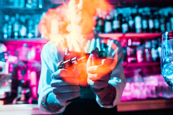 Expert barman maakt cocktail in nachtclub. - Foto, afbeelding