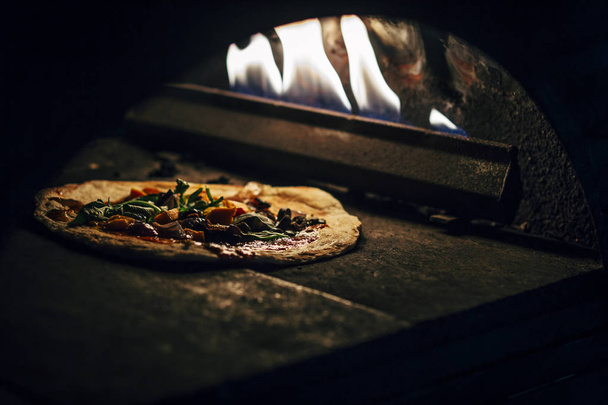Preparation of a pizza in oven. - 写真・画像