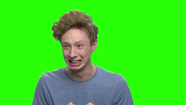 Angry teen boy emotions. Portrait of thrilled boy with nervous breakdown. Green screen hromakey background for keying. - Footage, Video