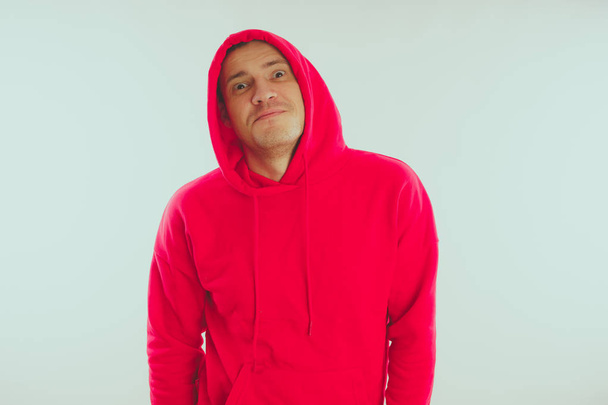 Crazy and charismatic guy posing. A man in a red tracksuit. Man isolated on white background, space for text - Foto, afbeelding